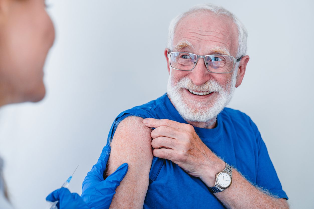 Flu season protection - A doctor administering a flu vaccine for a senior man.