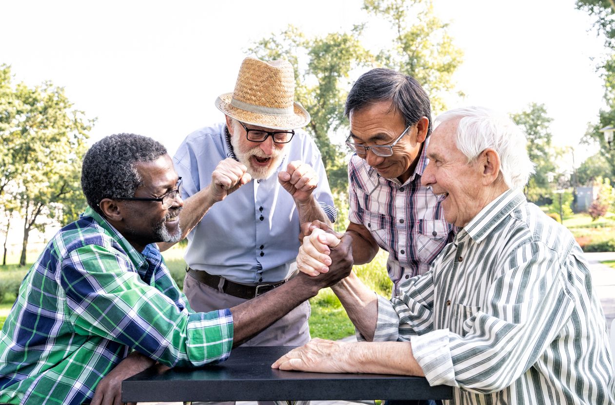 Preparing for retirement - A diverse senior group enjoying themselves in an arm wrestling game.